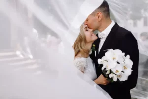 groom-black-tuxedo-hugs-tender-stunning-bride-while-they-stand