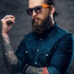 thoughtful-bearded-male-sunglasses-with-tattoos-his-arms-1